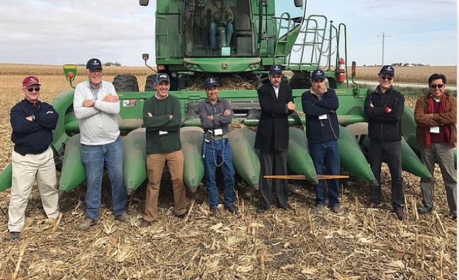 Eight People Standing In Front Of Tractor