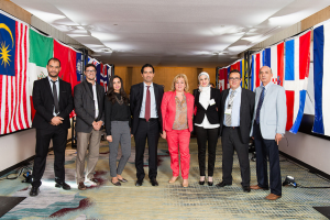 8 people standing in front of various flags