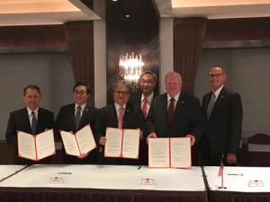 6 men showing off a signed trade agreement