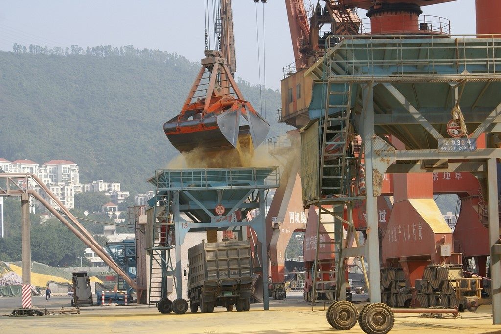 A crane dumping DDGS into a truck