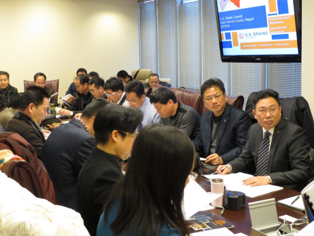 A room full of people crowded around a long table