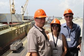 Three People Standing Next to Boat