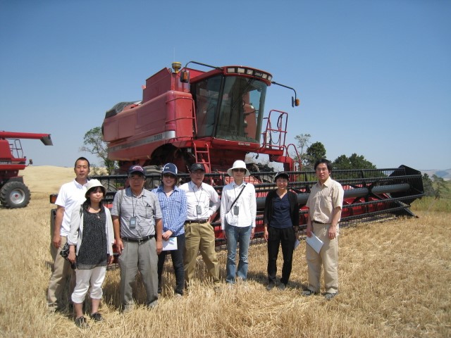 Eight People Standing In Front Of Tractor