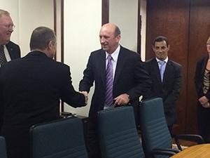 Two Men Handshaking Next to Desk