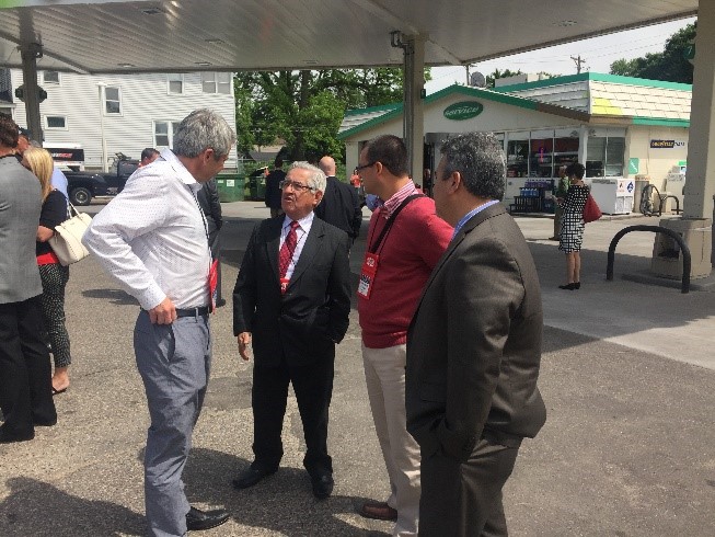 Four People Talking At Gas Station