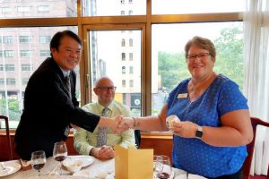 A man and woman shaking hands at a table