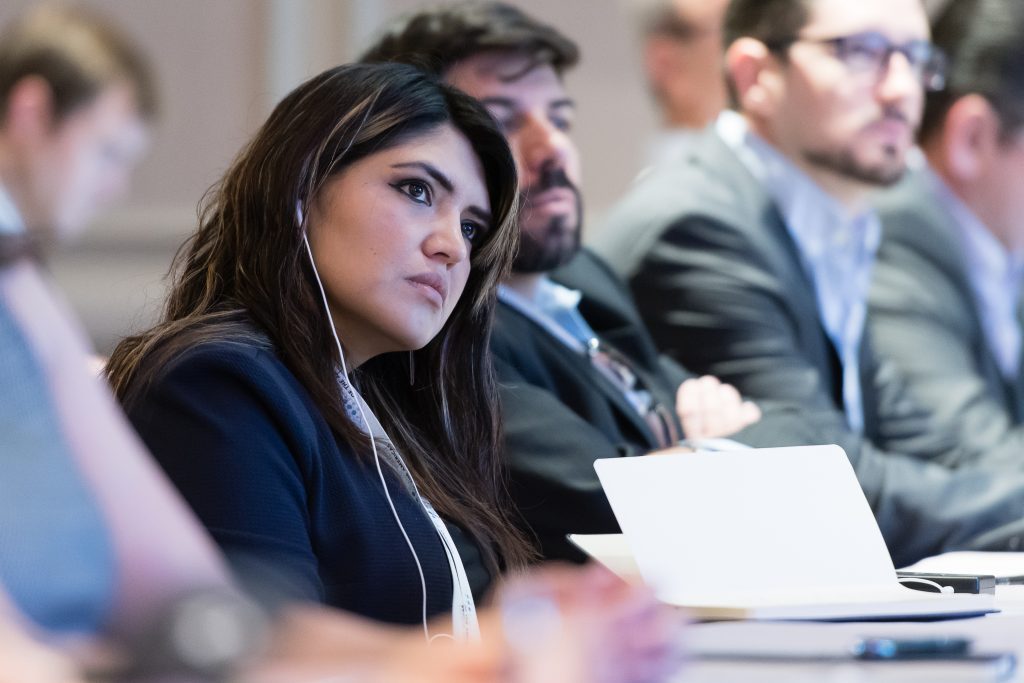 image of an attendee listening to a presenter at a conference
