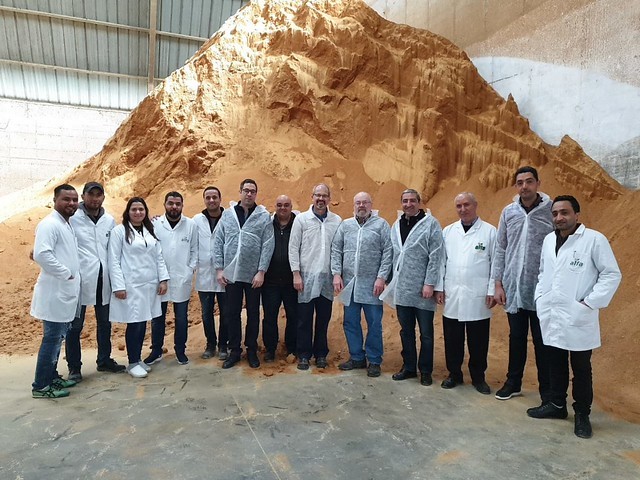 Tunisia DDGS team members group photo ,members standing in front of a large mound of DDGS