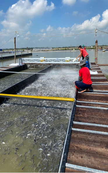 Two Men in Red Standing Next to Water
