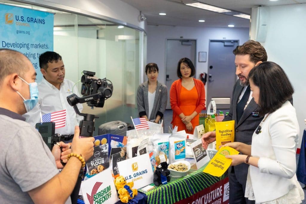 People Standing Around Crowded Table With Food