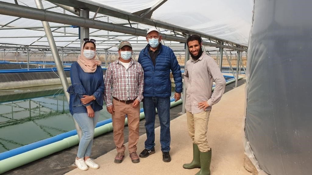 Four People Standing Next to Each Other