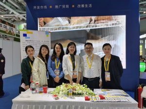 A group of people smiles in a trade show booth.
