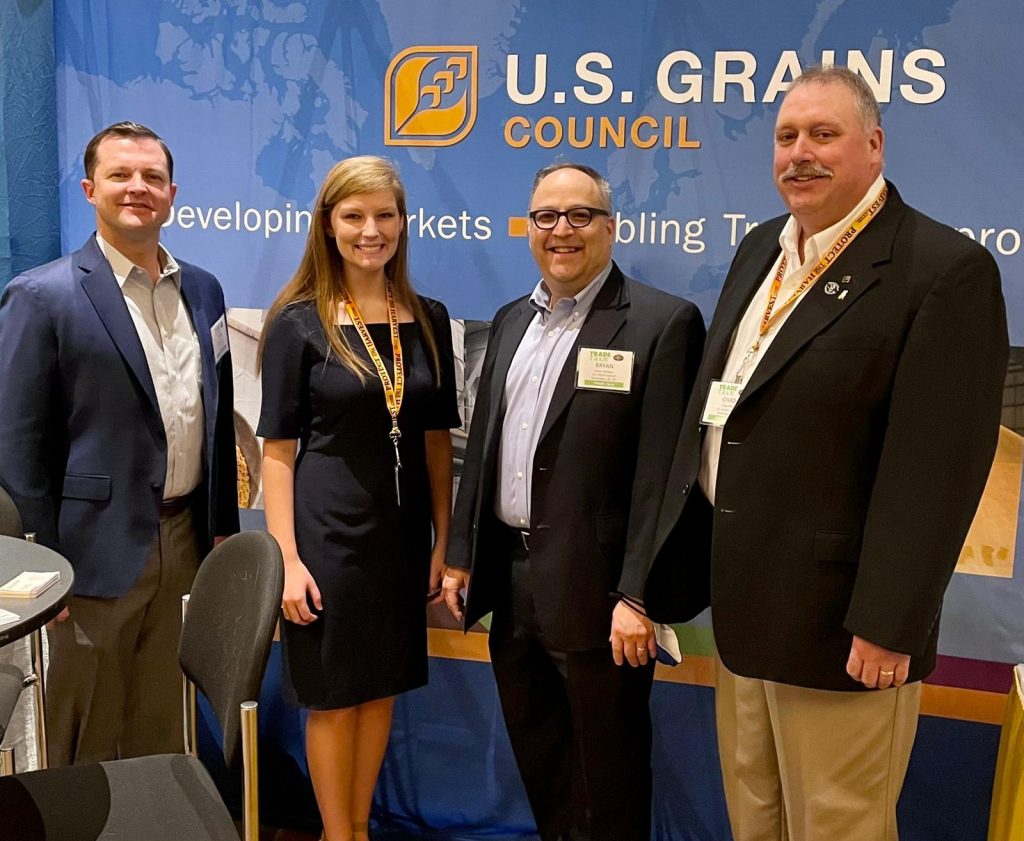 Group of people in business attire pose for photo.