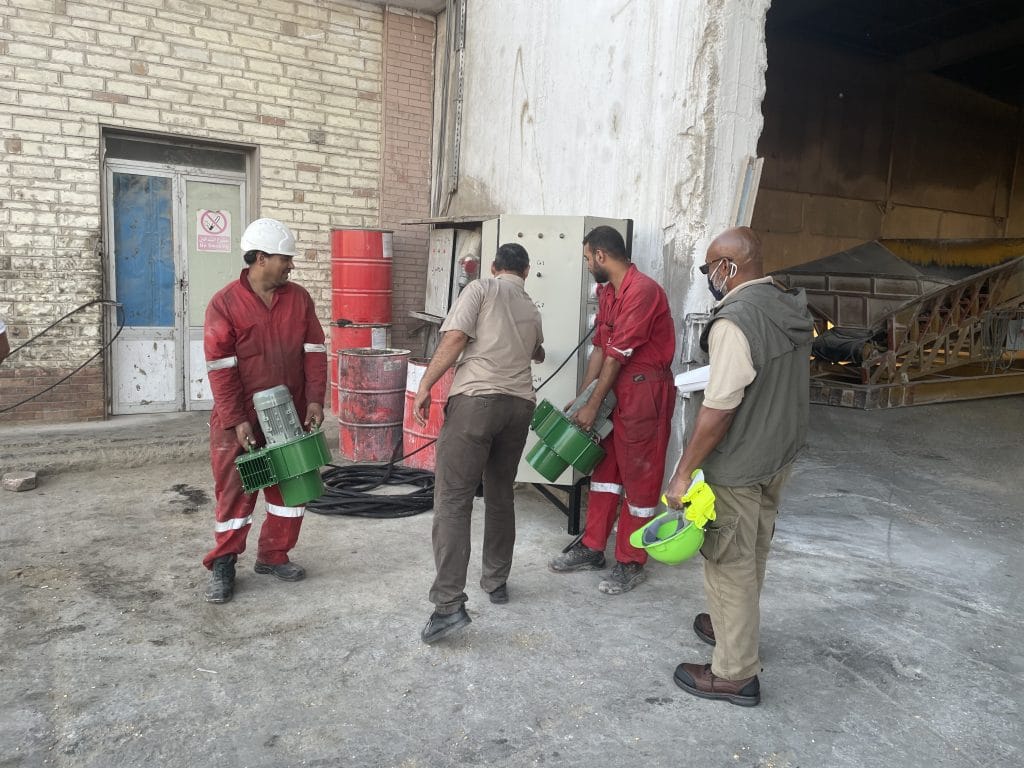 A man supervising the work of three other men.