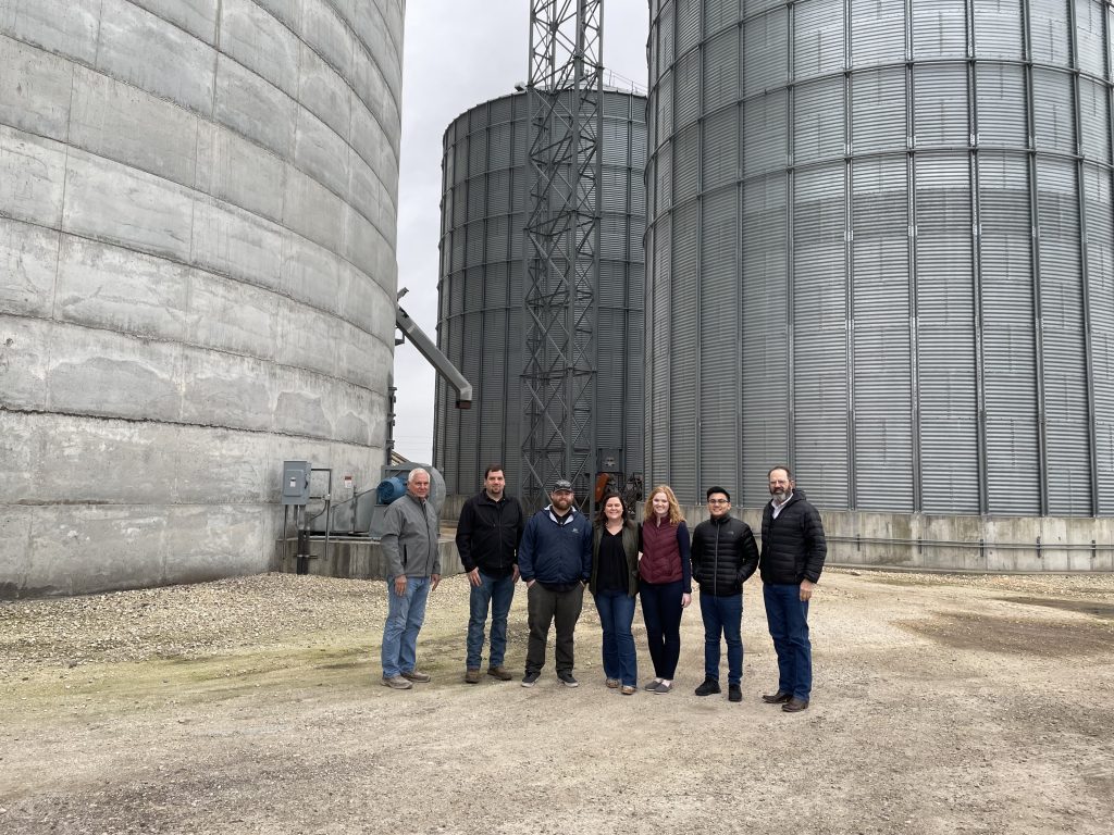 image of people in front of grain bins
