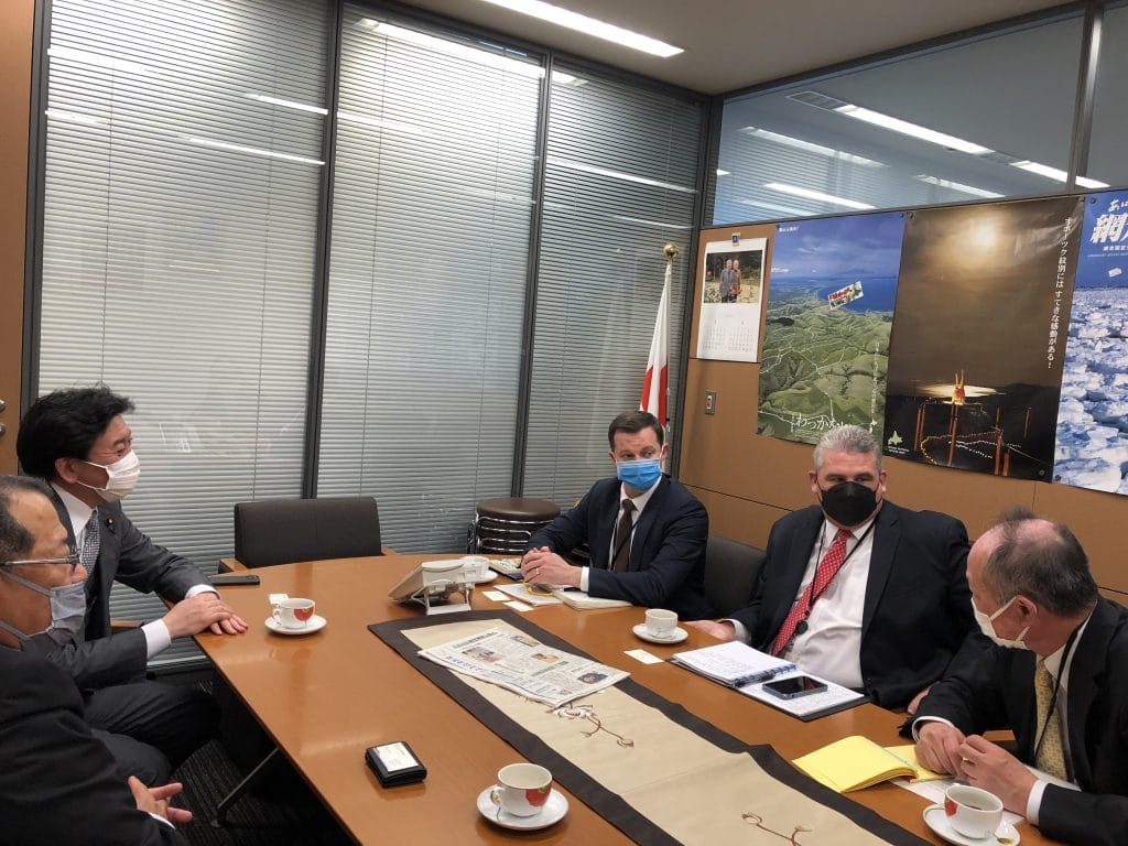 a group of men wearing masks sitting at a table