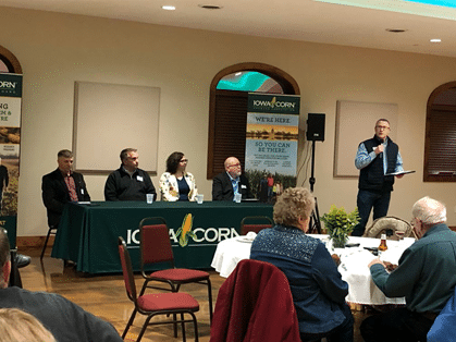 a group of people listening to a panel of people speak