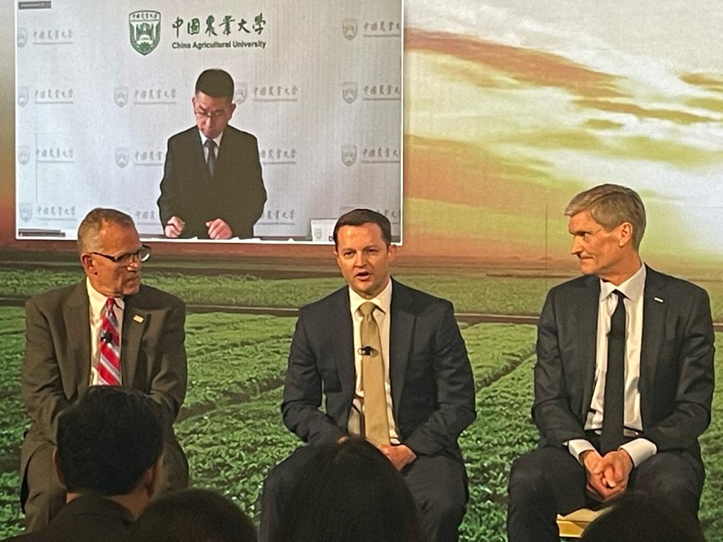three men speaking on a panel