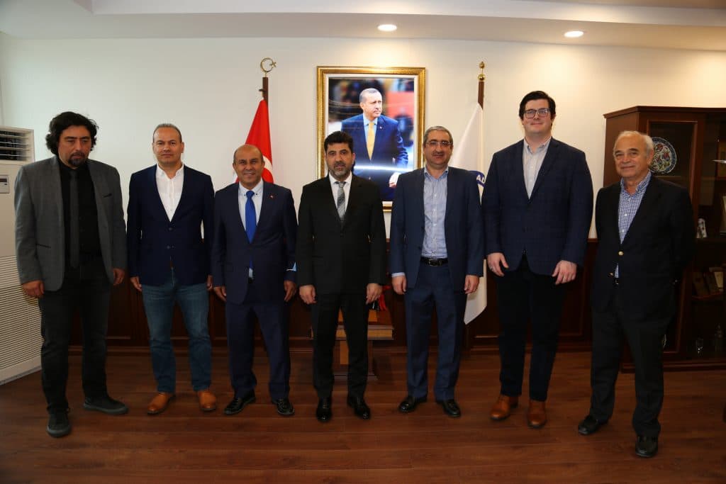 seven men in suits smiling for a photo