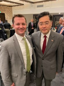 two men in suits smiling for a photo