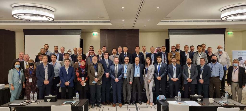 A large group of people posing for a photo in a conference room