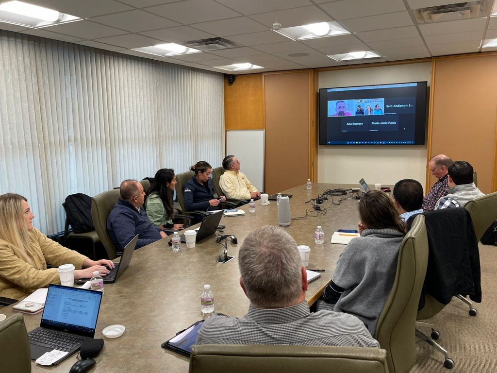 group of people at a table listening to a presentation