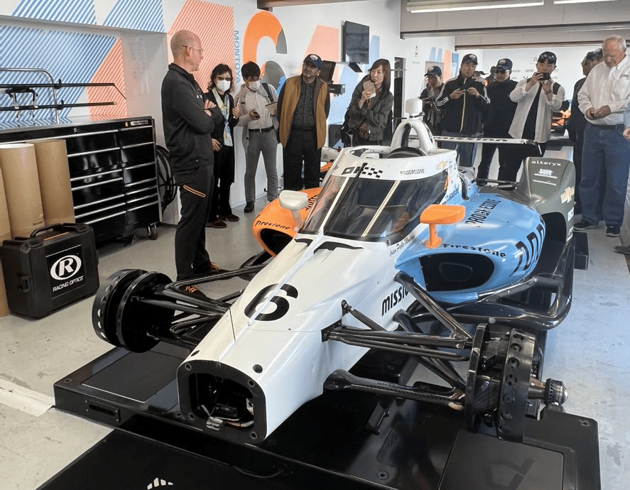 group of people looking at an Indy car