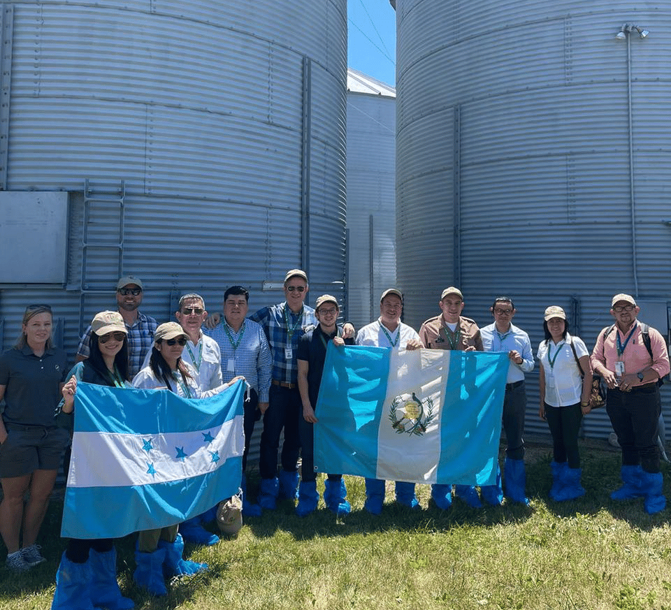 image of a group of people on a farm holding flags from Guatemala and Honduras
