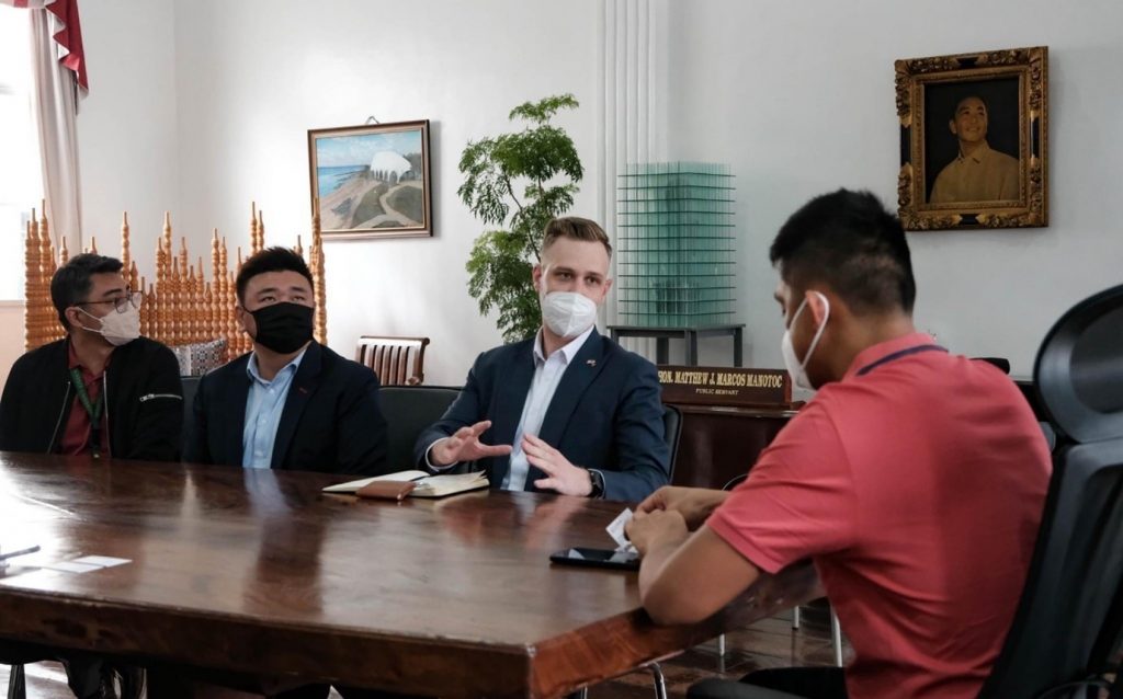 image of four men in masks talking at a table