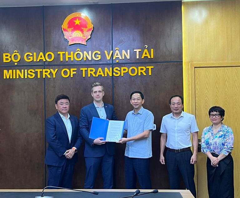 Image of four men and a woman holding educational materials for a photo