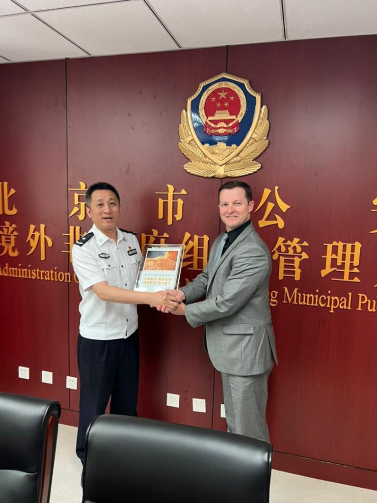 Two men shaking hands and holding a plaque