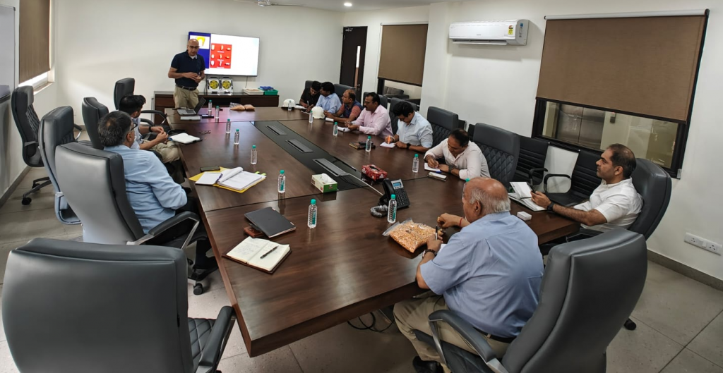 image of a group of men listening to a presentation around a conference room table