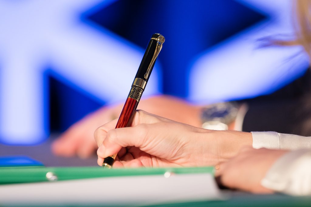 image of a hand signing a document