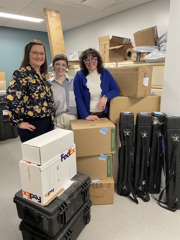 image of three women standing with shipping boxes