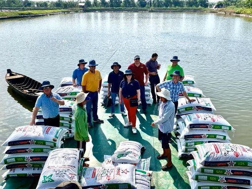 image of people standing by water on a fish farm