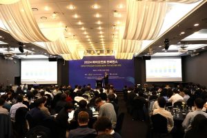 A crowd of people listening to a presentation