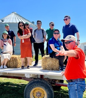 A group of people standing on a truck bed on a farm