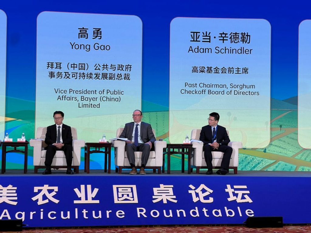 Three men sitting on a conference stage