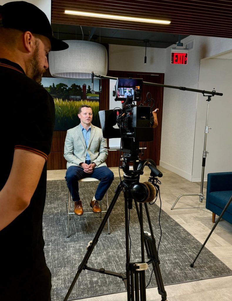 A man sitting in front of a camera and crew