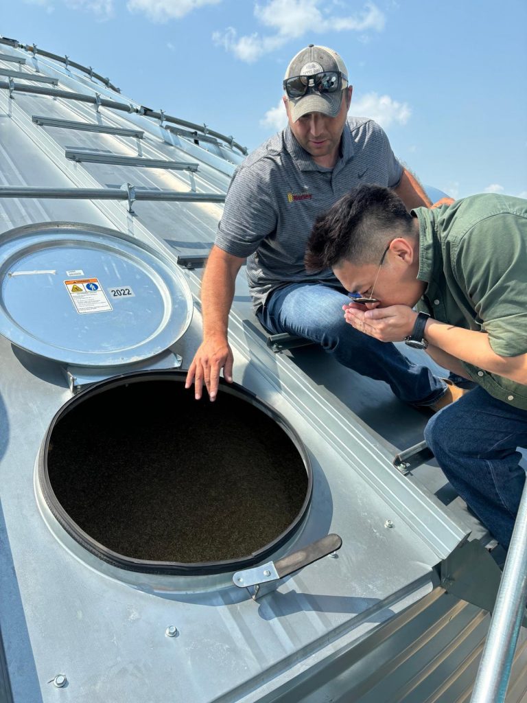 Two men inspecting a grains silo