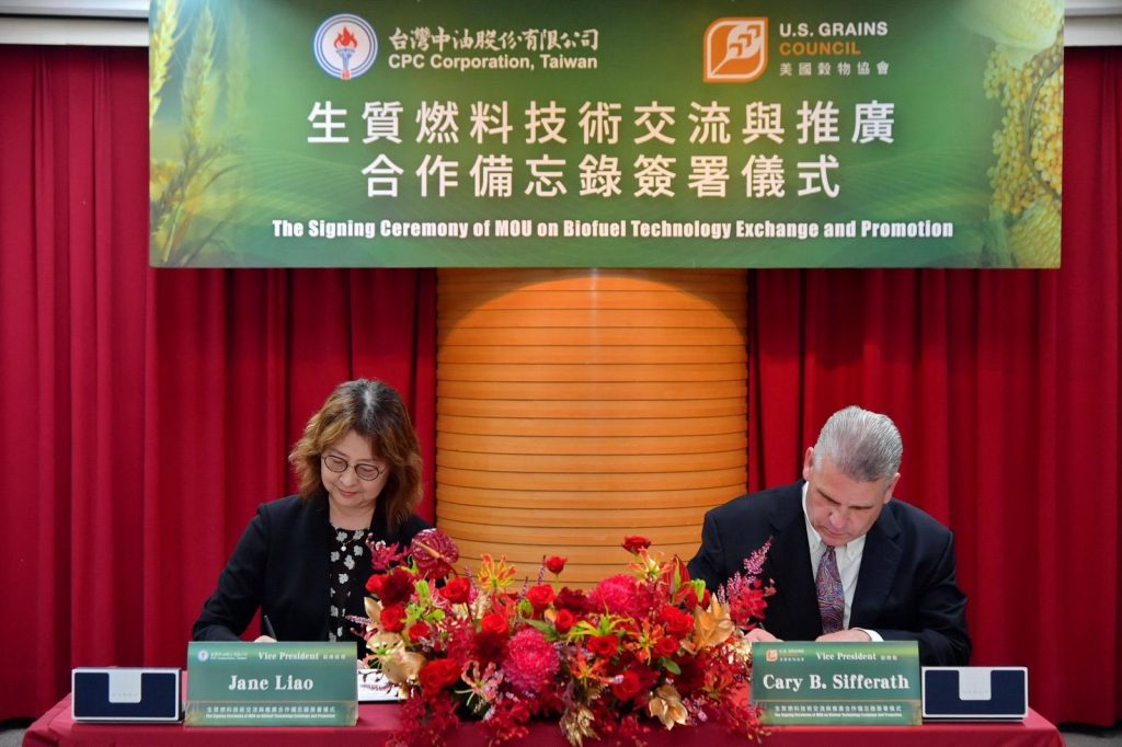 A man and a woman signing a document at a ceremony