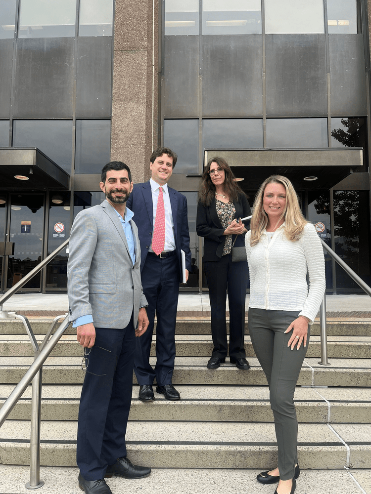 A group of four people in front of an office building